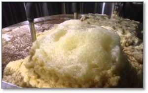 Depósito de acero inoxidable realizando la fermentación, se aprecia la maldá (residuos fermentativos)