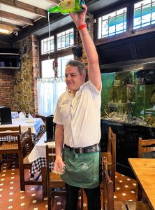 Camarero escanciando en sidrería La Pomar