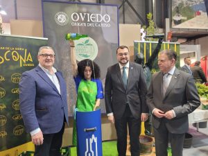 Persona escanciando junto a autoridades de Asturias en zona del stand Oviedo
