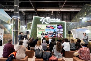 Persona realizando una presentación sobre Villaviciosa como destino turístico agroalimentario, con gran pantalla detrás de él y público