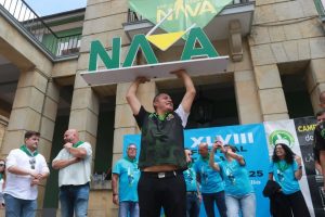 Jorge Vargas vencedor del Concurso de Escanciadores de Nava, levanta la estructura en miniatura de las letronas de Nava